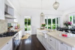Amplia cocina blanca con encimera beige