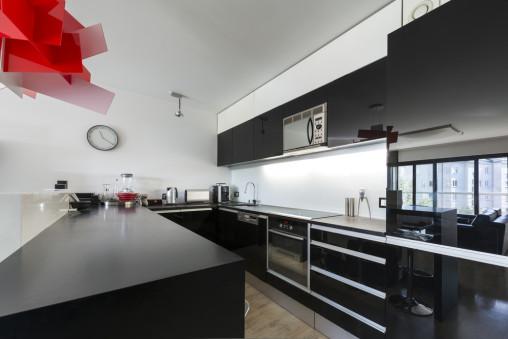 Moderna cocina en negro y lámpara roja