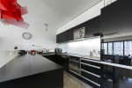 Moderna cocina en negro y lámpara roja