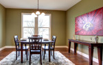 Comedor ecléctico con pared verde