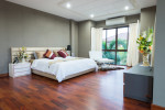 Dormitorio con suelo de parquet rojizo