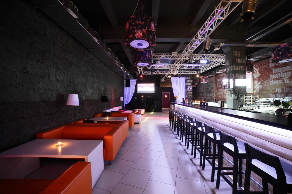 Pub estilo industrial con sofás naranjas