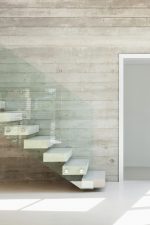 Escalera de piedra con barandilla de cristal