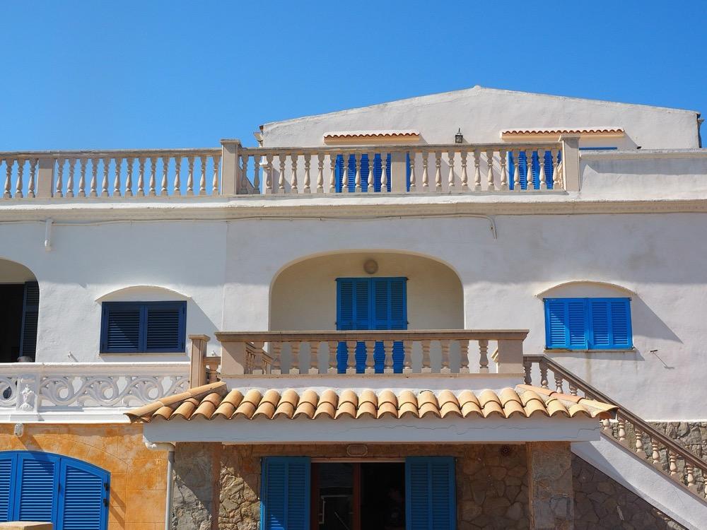 Fachada mediterránea con persianas azules